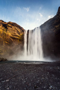 Scenic view of waterfall against sky