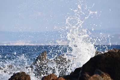 Water splashing in sea against clear sky