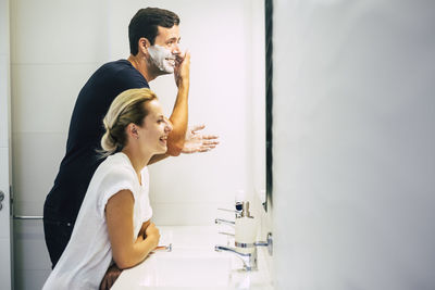 Side view of smiling couple in bathroom