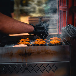 Midsection of person preparing food on barbecue grill