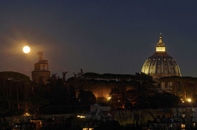Illuminated buildings against sky at night