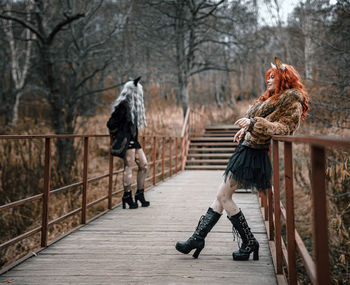 Rear view of woman walking on bridge during winter