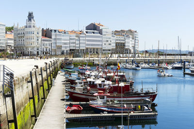 Boats moored at harbor in city