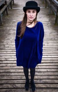 Portrait of a young woman standing on wooden floor