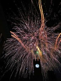 Low angle view of firework display at night