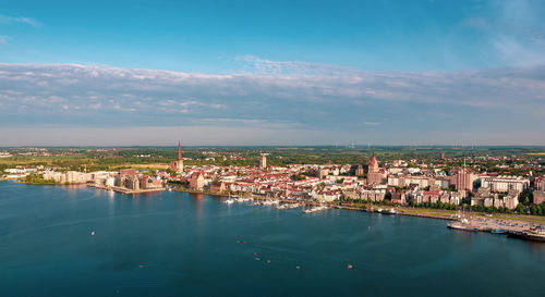 High angle view of townscape by sea against sky