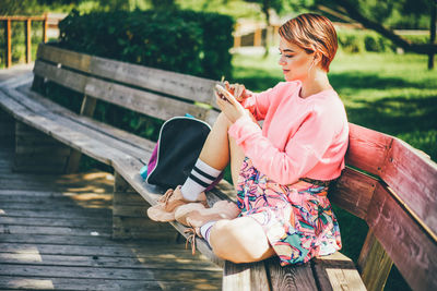 Side view of young woman using mobile phone