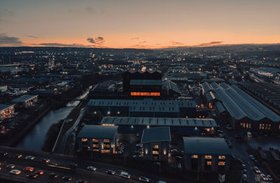 High angle view of illuminated city against sky during sunset