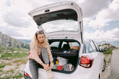 Portrait of woman standing by car