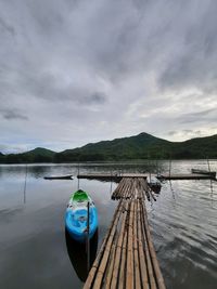 Boat moored in lake against sky