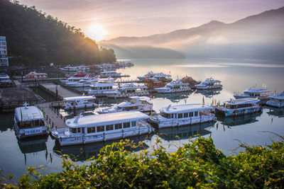 High angle view of ship moored at harbor during sunset