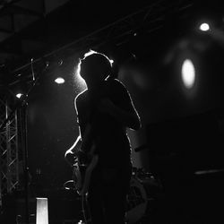 Low angle view of silhouette man playing guitar during concert