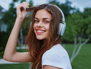 Portrait of young woman with eyes closed against plants