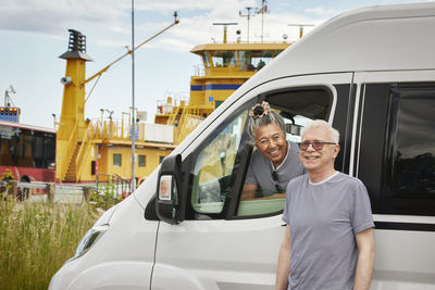 Portrait of smiling couple traveling by van