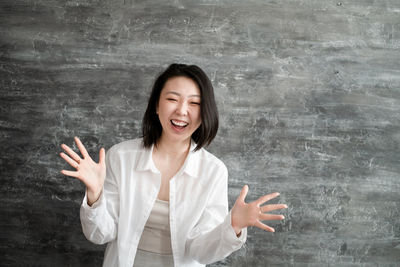 Portrait of woman gesturing against black background