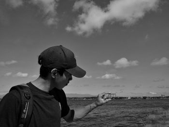 Boy looking at sea against sky