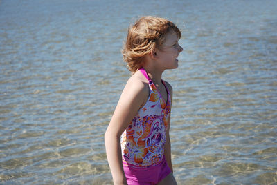 Side view of girl standing by sea