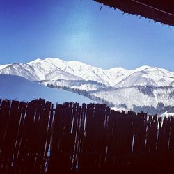 Scenic view of snow covered mountains against blue sky