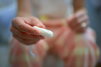 Midsection of woman holding tampon