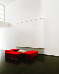 Red umbrella on tiled floor against wall at home
