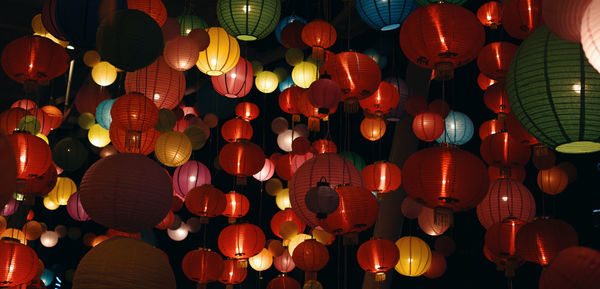 Low angle view of illuminated lanterns hanging at night