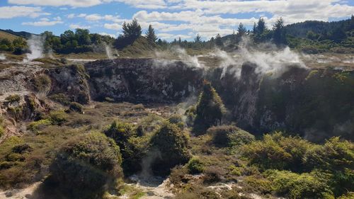 Scenic view of geothermal land against sky
