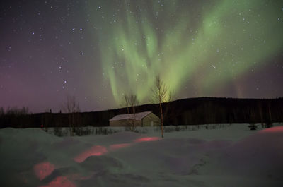 Scenic view of snowcapped landscape against sky at night