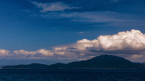 Scenic view of sea and mountains against sky