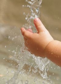 Close-up of hand splashing water