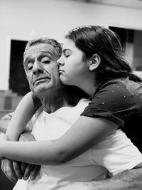 Girl kissing granddaughter at home