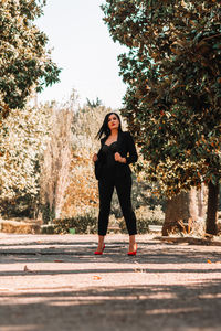 Portrait of female model standing on footpath at park