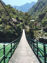 Footbridge over river against sky