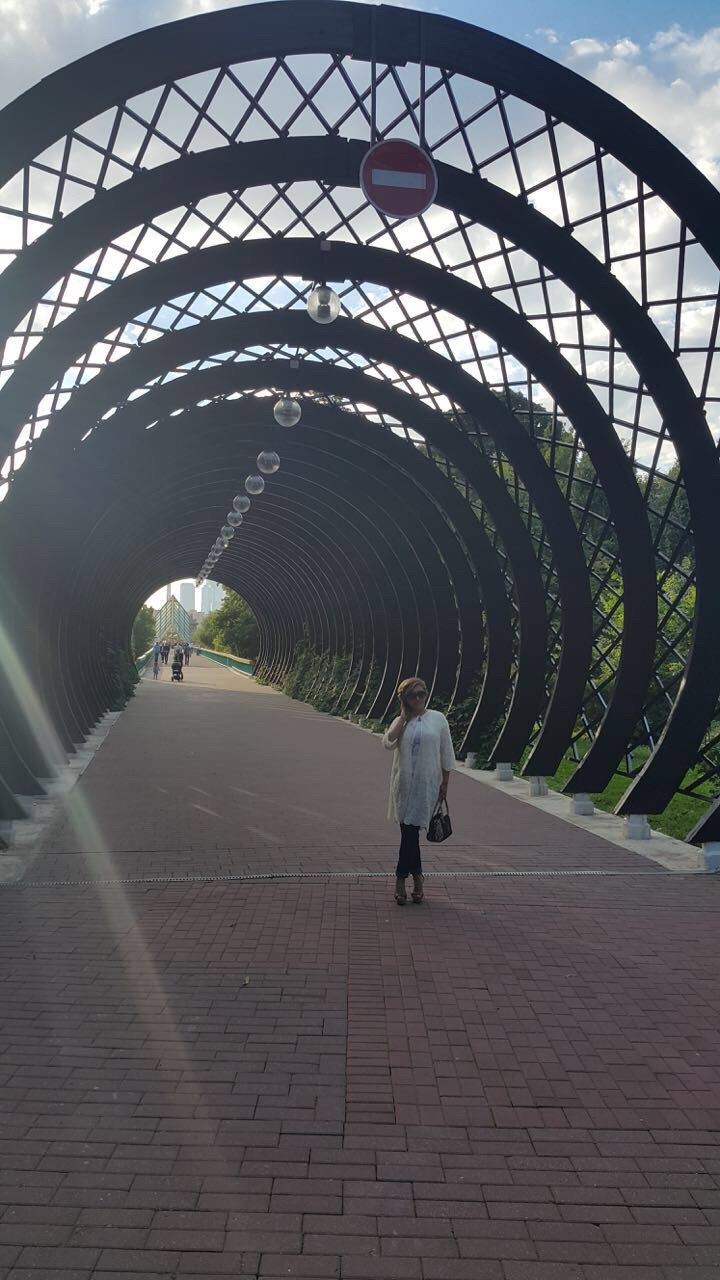 architecture, arch, built structure, full length, lifestyles, leisure activity, the way forward, sky, diminishing perspective, tunnel, day, unrecognizable person, travel destinations, walkway, vanishing point, casual clothing, city life