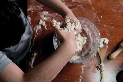 Zenithal view of child preparing pizza dough to make at home