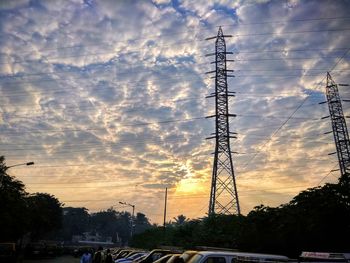 Low angle view of silhouette electricity pylon against sky