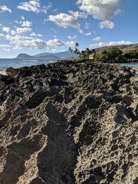 Scenic view of rocks on beach against sky