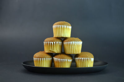 Close-up of cupcakes on table against black background