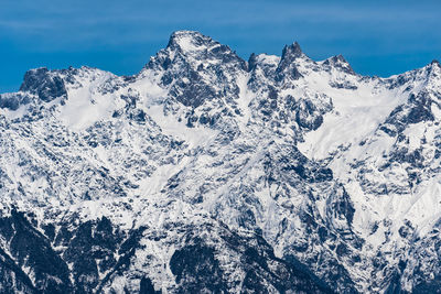 Scenic view of snow mountains against blue sky