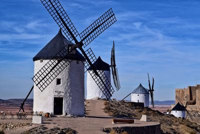 Traditional windmill on landscape against sky