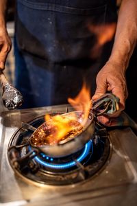 Midsection of man preparing food on stove