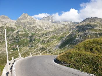 Scenic view of road by mountains against sky