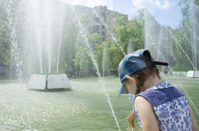 Portrait of woman splashing water fountain