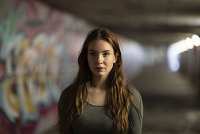 Portrait of young woman standing in tunnel