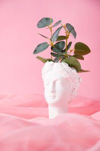 Bust of a greek goddess on a pastel pink background. minimal flat still life.