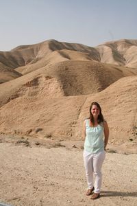 Portrait of smiling young woman standing in desert