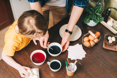 High angle view of friends holding drink on table