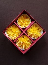 Directly above shot of yellow flowers in box on table