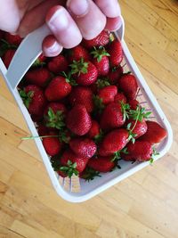 Cropped image of hand holding strawberry basket