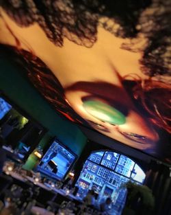 Reflection of man on illuminated mirror