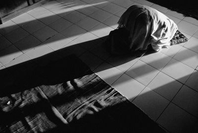 High angle view of woman sitting on tiled floor